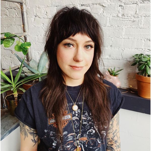 10. Punk Style Long Shag Hairstyles with Textured Bangs Cuts- a Woman with blue t-shirt