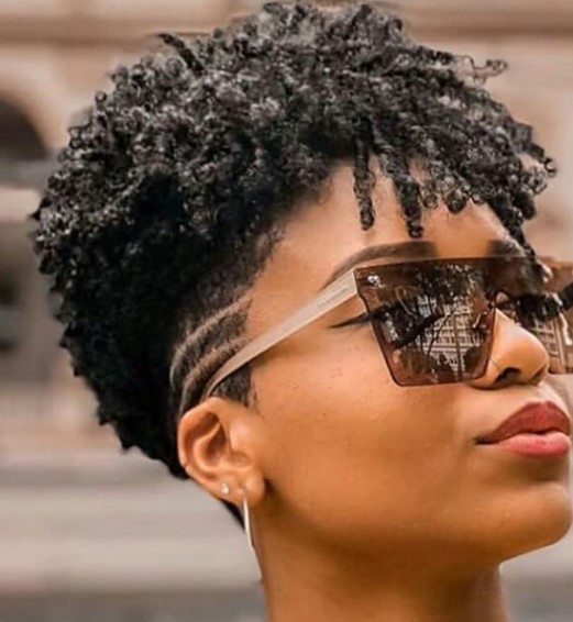 a woman with Low Fade with Side Razor Design and Curly Front Strands wearing sun shade