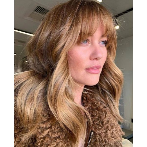 Copper Blonde Hairstyle with Straight Bangs and Waves
