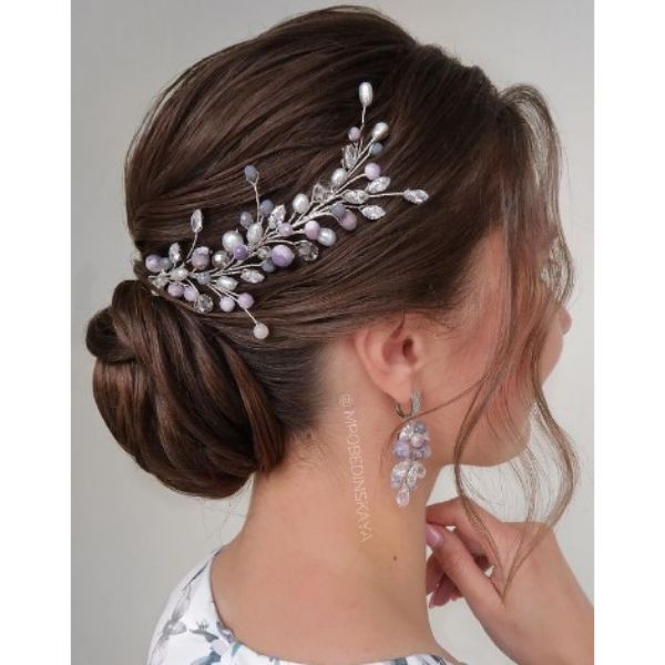 Elegant Low Twisted Bun With Floral Pieces And Falling Strands