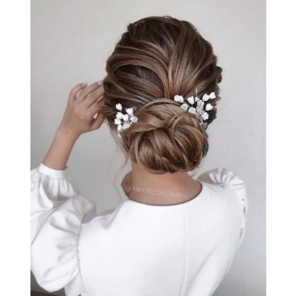 Wedding Updo With Twisted Strands And White Floral Pieces