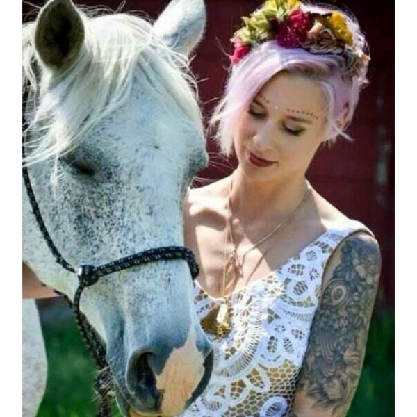 a woman with Short Pink Pixie With Flower Crown while holding a horse