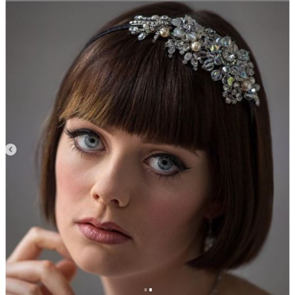 a woman with Vintage Inspired haircut With Sleek Bon And Headpiece
