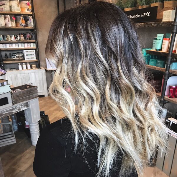 Cool-Toned Blonde Color Melt Curly Hair - a woman with long hair and black shirt