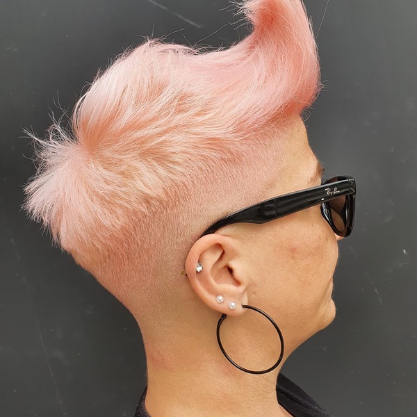 Edgy Pink Pixie Hairstyle - A woman wearing earrings and sunglass