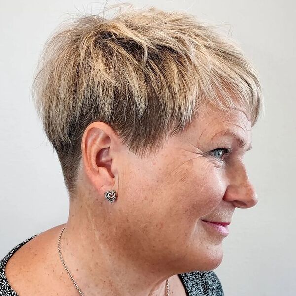 Short Edgy Spiky Pixie Cut - a woman wearing a heart shaped earrings