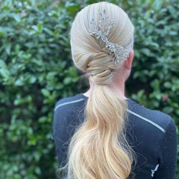 Chic Bridal Ponytail Updo with Decor - A woman with hair decor wearing a longsleeve