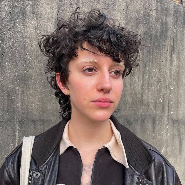 Messy Top Curly Mullet Hairstyle - a woman wearing a jacket