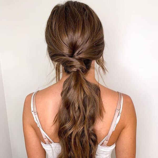 Sleek Curl Twisted Ponytail - A woman wearing a sleeveless top