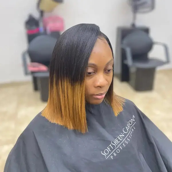 Bob Cut with Honey Blonde Ombre - a woman wearing a black cape