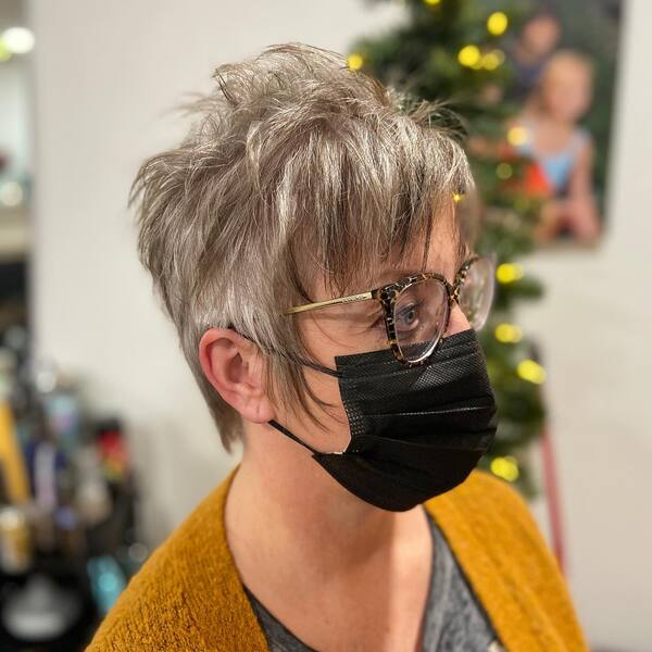 Messy Pixie Cut with Arctic Blonde - a woman wearing a black face mask