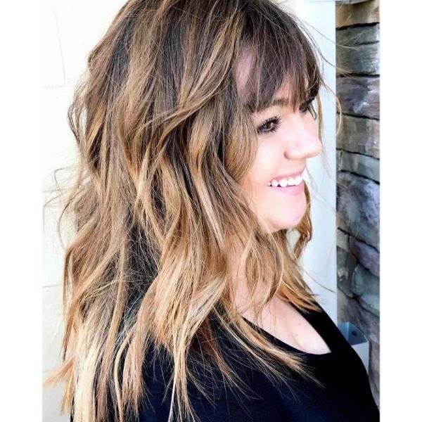 Trendy Balayage for Long Wavy Shag Haircuts for Women-  a woman in a black blouse