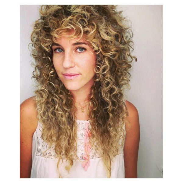 Voluminous Curly Layered Hairstyle with Messy Bangs for Blonde Hair
