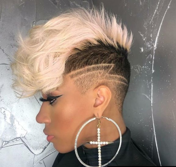 a woman with Blonde Hair with Razor Design wearing a circular and cross earrings