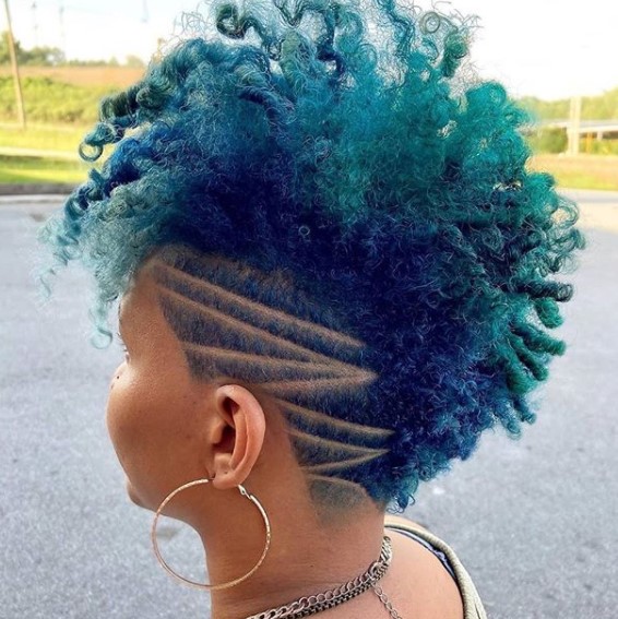 a woman with Dark Turquoise Mohawk with Ziz-zag shaved hairstyles for black women with a circular earring