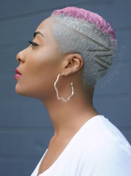 a woman with High Fade with Side Razor Design and Pink Top wearing a big earring