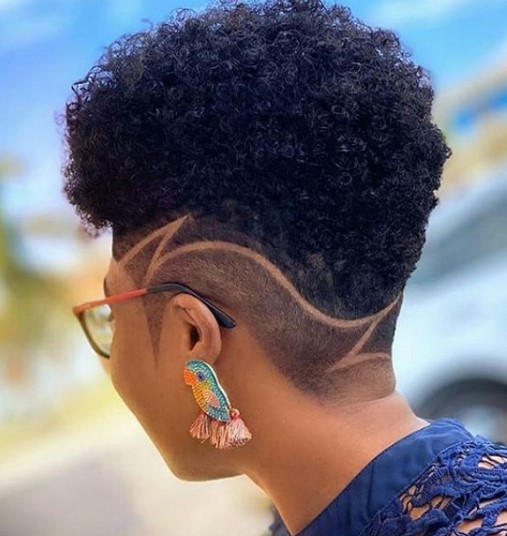 a woman with High Fade with Side Razor Design and a bird figure earring