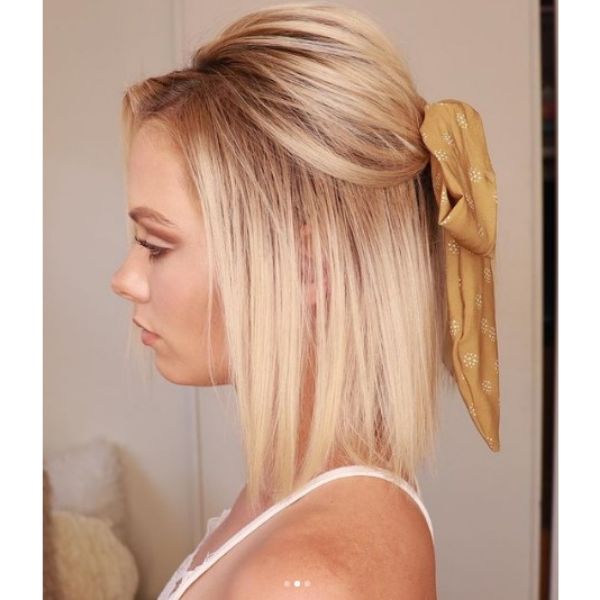 A girl with her blonde bob half-up with ribbon hairstyle