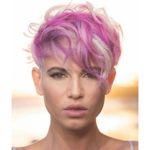 A girl with her curly pixie cut with magenta strand hairstyle