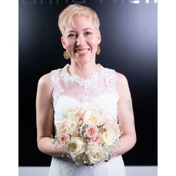 a woman with Light Blonde Pixie With Messy Styling while holding a bouquet of flowers 