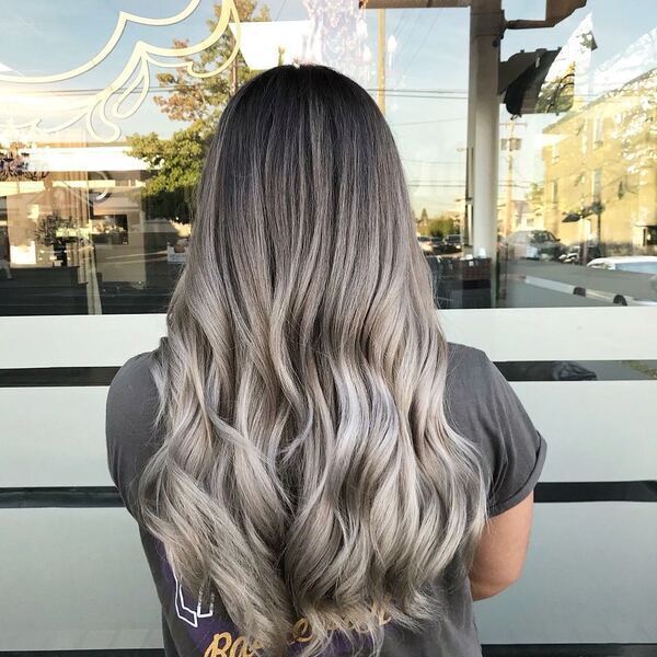 Grey Silver Toned Ash Blonde Wavy Hair - A woman wearing a grey printed shirt