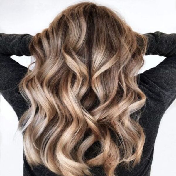 Long Curly Hair with Bronde Balayage - A women in a dark grey sweater