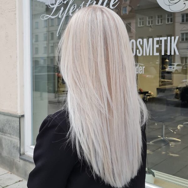 Silver Grey Long Layered Ice Blonde Hair - A woman wearing her jacke