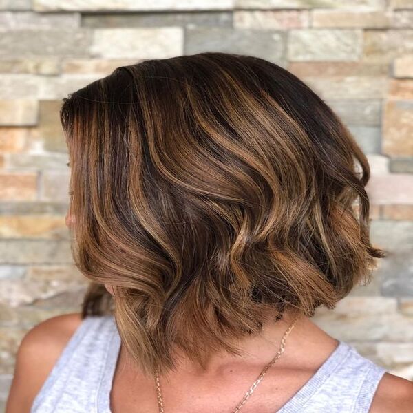 Trendy Layered Brunette Bob Hair - A woman in her grey sleeves top