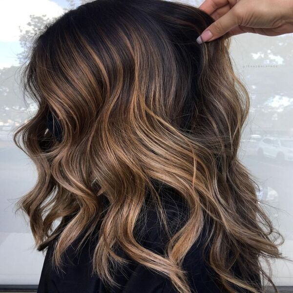 Brunette Hair with Caramel and Golden Highlights - A women with a black salon cape
