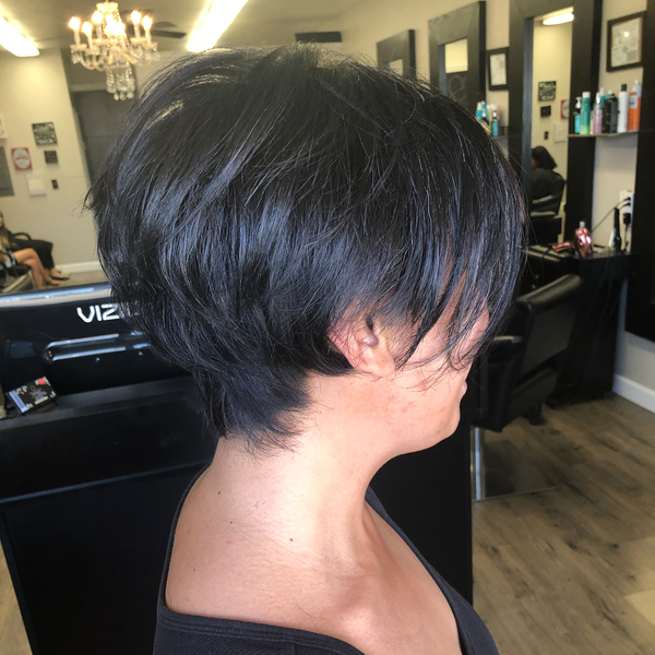 Dark Black Bubbly Feathered Pixie Haircut - A woman inside the salon