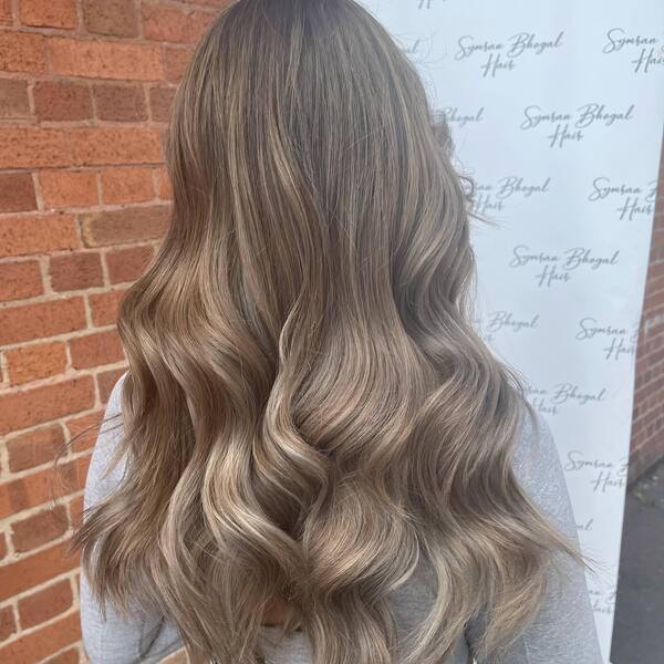 Ash and Caramel Balayage for Long Hair - A woman with a grey top