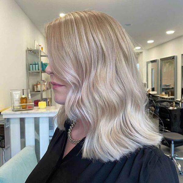 Soft Ash Blonde Balayage for Skin Tone - A women in a black blouse