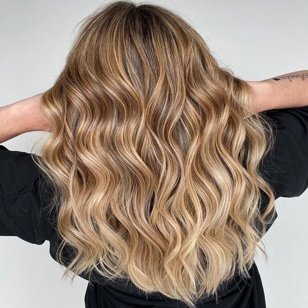Caramel Blonde Highlighted for Fine Hair - A woman with a tattoo on right hand