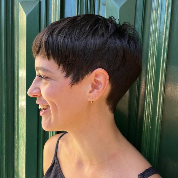 Bowl Pixie Hairstyle - A woman wearing a grey sleeveless