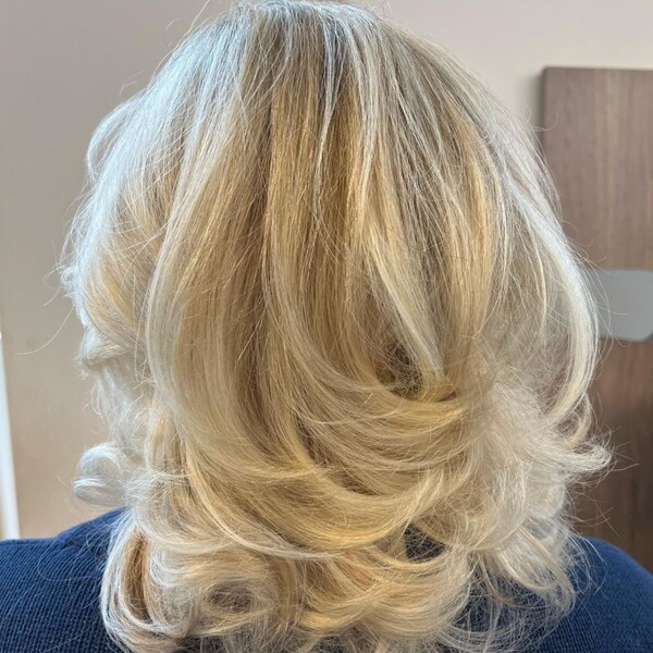 Ash Blonde for Warm Hair - a woman wearing a blue jacket