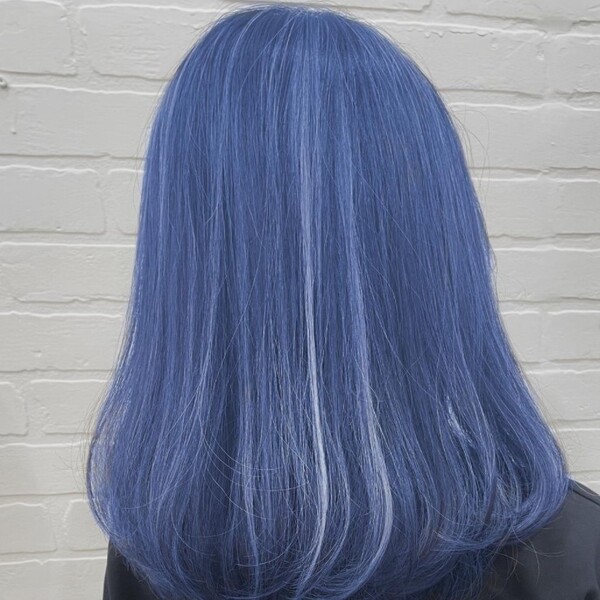 Blue Hair - a woman facing a white brick wall