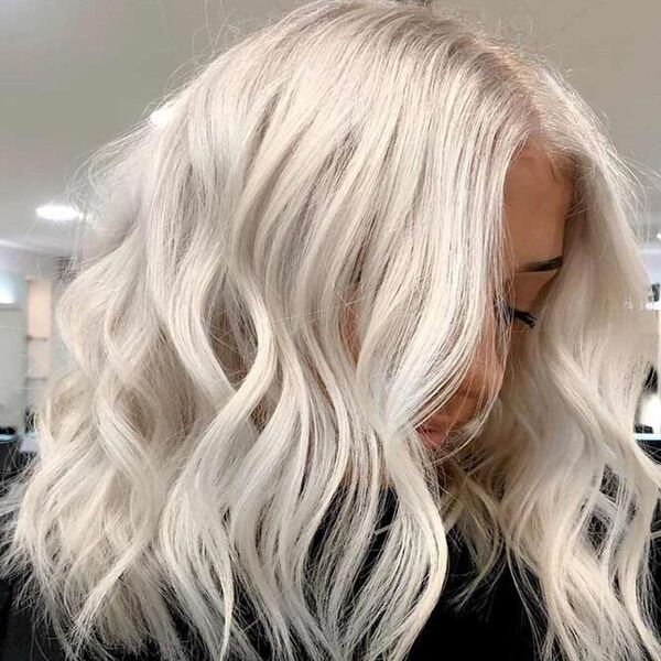 Catchy White Blonde Balayage - a pretty girl in a black barber's cape