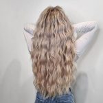 Curly Ash Blonde Hair - a woman wearing a white fitted shirt