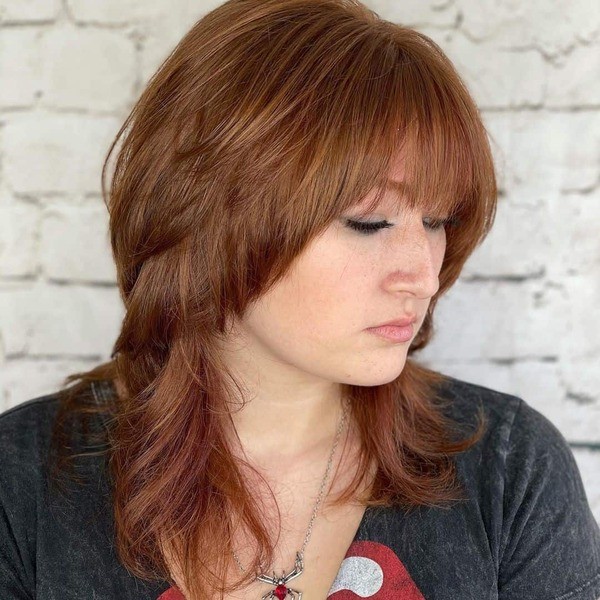 Gorgeous Brown Wolf Hairdo - a woman wearing a necklace with a spider symbol pendant