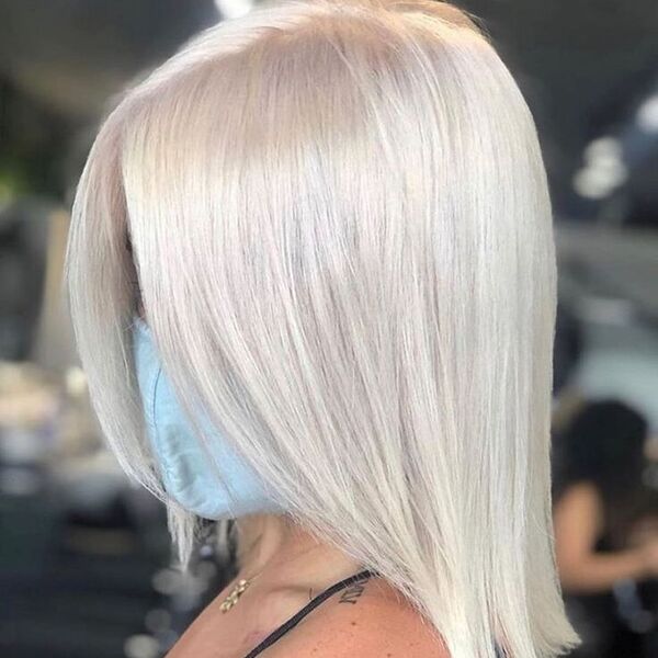 Icy Platinum Blonde Hair - a woman wearing facemask and has tattoo