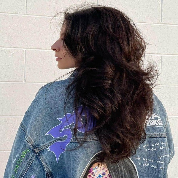 Long and Dramatic Voluminous Wolf haircut - a woman wearing a big denim jacket