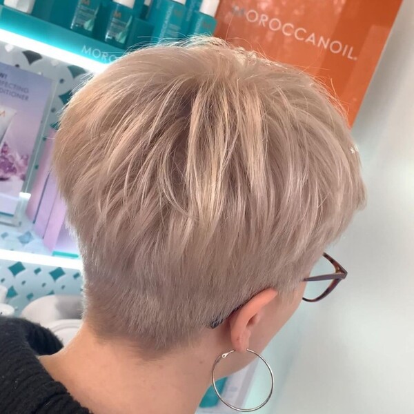 Pearl Ash Blonde Pixie - a woman wearing an eyeglasses and large round earring