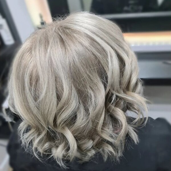 Pearly White Ash Blonde - a woman sitting in a salon chair