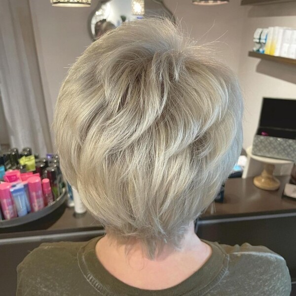 Pixie cut platinum hair - a woman wearing an army green shirt