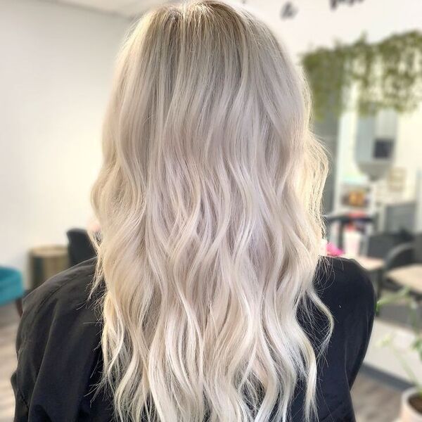 Platinum Blonde Balayage for Long hair - a woman wearing a black barber's cape