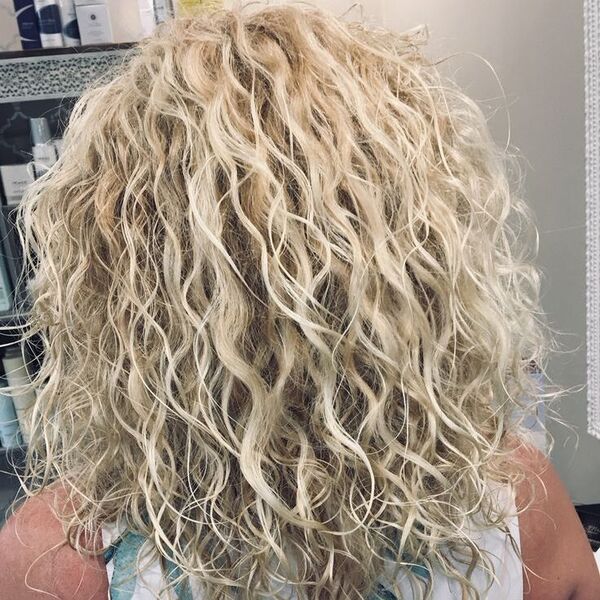 Platinum Blonde Curly Hair - a woman wearing a sleeveless blouse