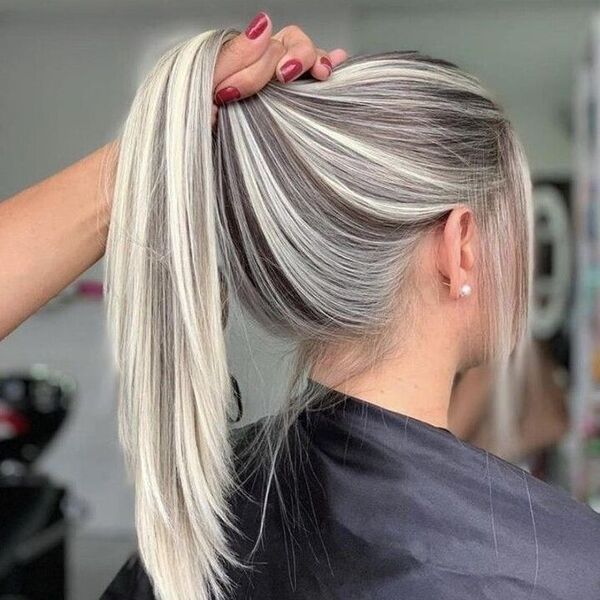 Platinum Blonde Hair with Lowlights - a girl wearing a black barber's cape