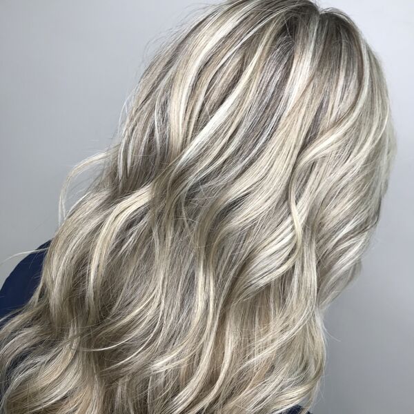 Platinum Highlights on Dirty Blonde Hair - a woman wearing a deep dark blue shirt