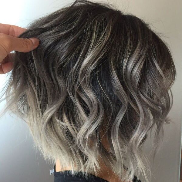 Sandy-Ashy Balayage - a woman with someone holding the strands of her hair