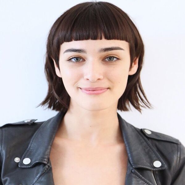 Wolf Cut and Micro Bangs - a pretty young woman wearing a black leather jacket